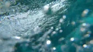 水下慢动作：水晶般清澈的桶波在深海中冲破相机。相机从富埃特文图拉阳光明媚的海滩下<strong>降到</strong>深晶莹的海水下巨大的冒泡的海浪.